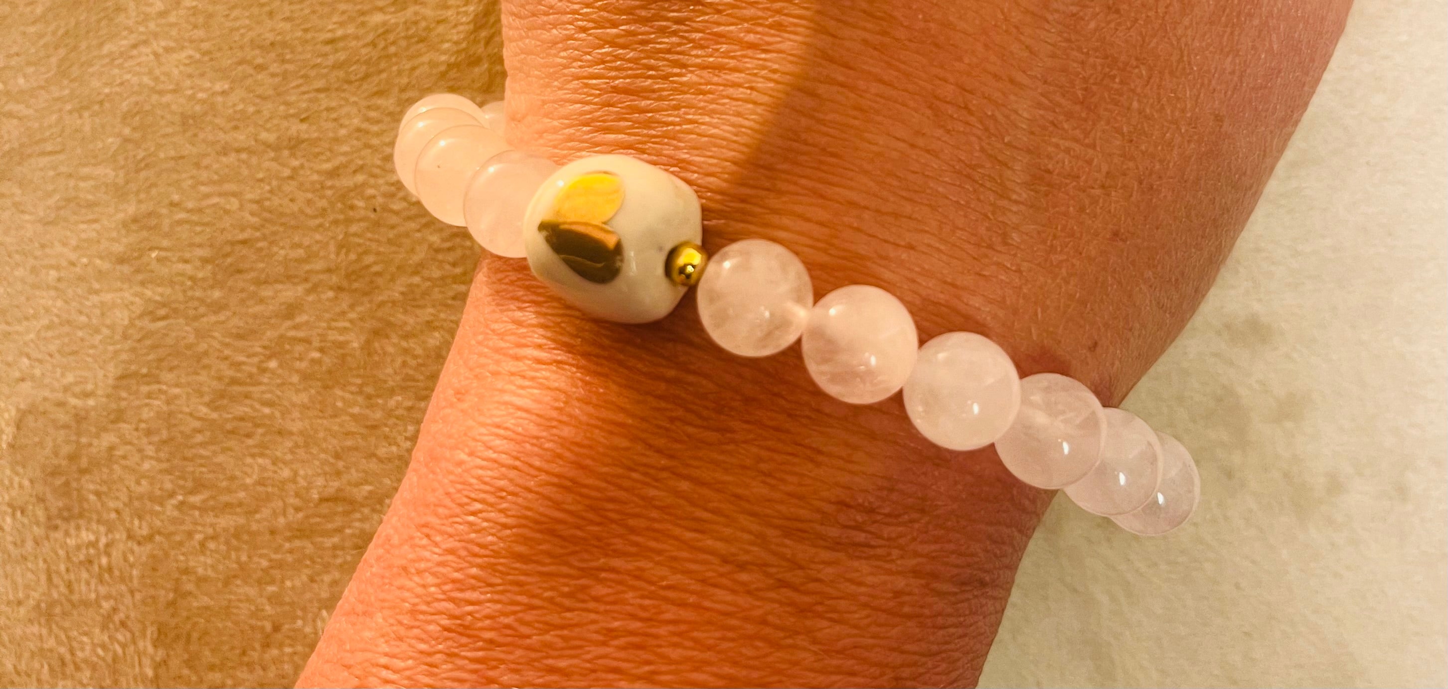 Bracelet rose quartz: pierre de l’amour avec perle de porcelaine avec cœur en or.